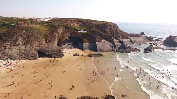 As pessoas relaxam na praia Zambujeira de Mar perto das rochas vista aérea — Vídeo de Stock