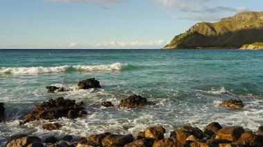 Dalgalar kayalık sahil şeridine çarpar. Gölgeler kayalık yüzeyde hareket eder. Mallorca 'dan güzel bir deniz manzarası. Seyahat, doğa, arka plan için ideal.