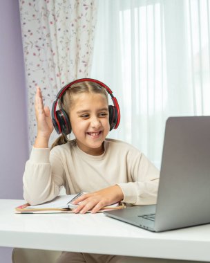 Gülümseyen liseli kız evde internetten öğreniyor, el çabukluğu ile büyütülüyor. Mutlu ve parlak eğitim anı evde eğitim ve uzak çalışma görselleri için mükemmel.