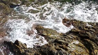 Dalgalar kayalık kıyılara çarpıyor ve köpürüyor. Dinamik doğal deniz arka planı, seyahat için mükemmel, doğa. Mallorca, İspanya 'da çekildi