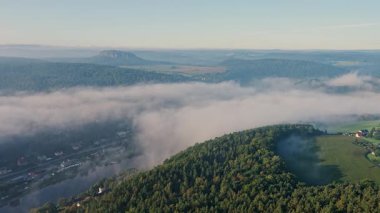 Almanya 'da Sakson İsviçre Ulusal Parkı' nda Lilienstein yakınlarındaki Misty Valley manzarası. Sabah sisi manzarayı kaplıyor, sakin ve manzaralı dağ manzarası yaratıyor..