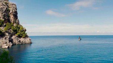 İspanya 'nın Mallorca kentindeki Sa Calobra Körfezi' nin kristal berrak turkuaz sularında demirli turist yatı. Dramatik uçurumları ve barışçıl doğal çevresi olan Akdeniz sahili