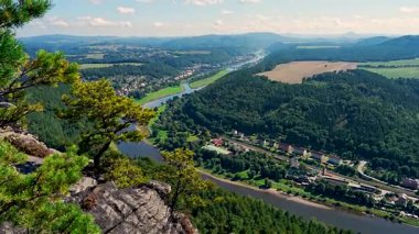 Köy manzarasının uçurumundan göz kamaştırıcı manzara, geniş yeşil çayırlar, Elbe Nehri. Güneşli bir gün. Almanya, Dresden yakınlarındaki Sakson Ulusal Parkı