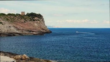 Mallorca, İspanya 'daki Torre d Albarca kulesiyle birlikte kayalık kayalıklarda geziniyor. Açık mavi deniz ve güneşli gökyüzünün altında Akdeniz kıyı manzarası.