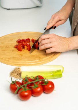 Modern mutfakta yemek pişiren, besleyici ev yapımı yemekler için taze sebze dilimleyen bir kadın. Sağlıklı yaşam tarzı, dengeli diyet kavramı.