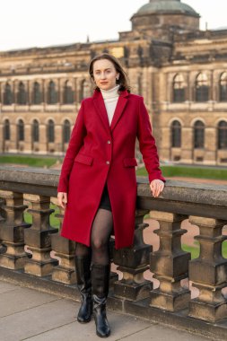 Arkasında Zwinger Sarayı olan tarihi Dresden, Almanya 'yı keşfeden kırmızı paltolu şık Avrupalı kadın. Şehir gezisi, mimari, gezi ve modern yaşam tarzı..