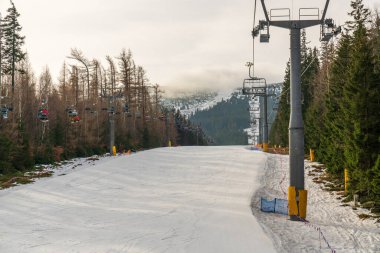 Kışın dağ otelinde kayakla gezen turistler. Karlı manzara, kış arka planı, kış sporları ve mevsimsel seyahat konsepti. Karpacz, Polonya.