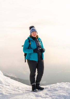 Sırt çantalı kadın gezgin, karlı Snezka zirvesinde duruyor, kış manzarasının tadını çıkarıyor, dağ manzarasının. Polonya 'da seyahat, macera, özgürlük, açık hava yaşam tarzı.