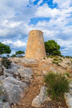 Torre Nova des Cap Vermell, İspanya, Mallorca, Canyamel 'deki tarihi kıyı taşı kulesi, Akdeniz ve dramatik kayalık sahillerin üzerinde duruyor..