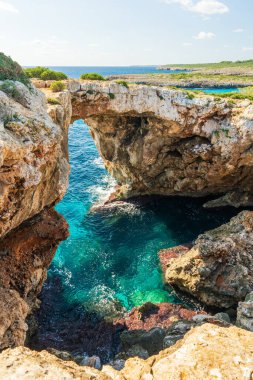 Doğal kaya kemeri Pont Natural dEs Calo Blanc Mallorca, İspanya 'daki turkuaz deniz üzerinde. Manzaralı Akdeniz kıyı şeridi ve popüler seyahat noktası