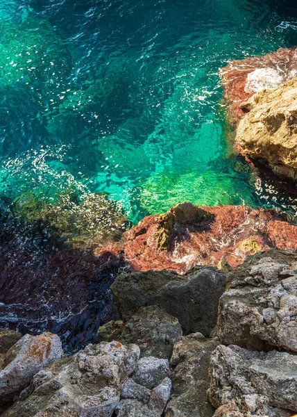 Turkuaz deniz suyu, İspanya 'nın Mallorca kentindeki Pont Natural dEs Calo Blanc' ın doğal taş kemerinin altında güneş ışığında parlıyor. Akdeniz kıyı manzarası ve seyahat rotası.