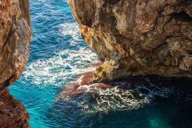 Es Calo Blanc, Mallorca 'da kristal berraklığında turkuaz bir denizde taş kemer. Yaz tatili, seyahat ve turizm konsepti.