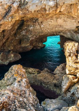 İspanya, Mallorca 'daki Es Calo Blanc' ta turkuaz suyla çevrili doğal taş kemer. Manzaralı kıyı manzarası ve Akdeniz 'deki popüler seyahat beldesi.