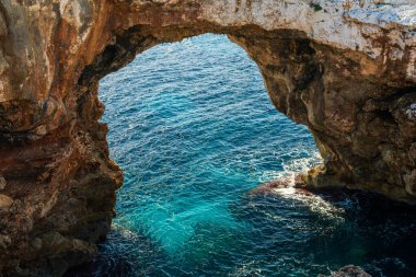 Doğal kaya kemeri Pont Natural dEs Calo Blanc Mallorca, İspanya 'daki turkuaz deniz üzerinde. Manzaralı Akdeniz kıyı şeridi ve popüler seyahat noktası