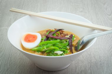 Sığır şehriye çorba kasesi ile ahşap bir zemin üzerinde beyaz.