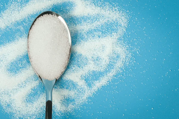 Sugar spoon blue background. — Stock Photo, Image