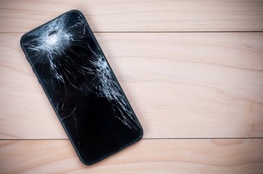 Smartphone ile kırık ekran mobil. Ahşap arka plan