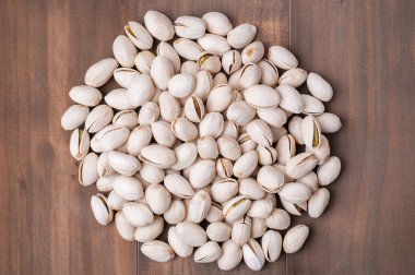 Ahşap arka plan üzerinde kabuk kavrulmuş ve tuzlu fıstık