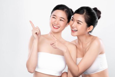 Beyaz arka planda temiz tenli iki güzel Asyalı kadın, yüz bakımı, yüz bakımı, kozmetoloji, güzellik ve kaplıca, Asyalı kadın portresi..