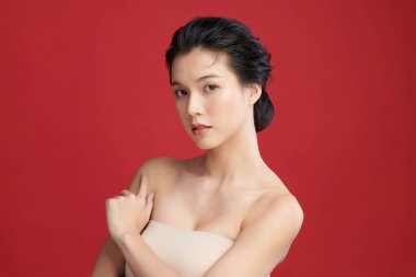 Güzel genç Asyalı kadın, kırmızı arka planda temiz ten, yüz bakımı, yüz bakımı, kozmetoloji, güzellik ve kaplıca, Asyalı kadın portresi..