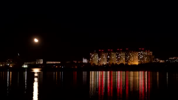 Timelapse. Arranha-céus com luzes de sinalização. A lua está se movendo através do céu — Vídeo de Stock