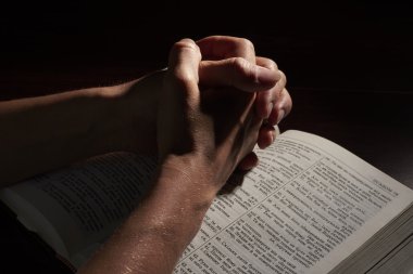 İncil'in üzerine katlanmış eller