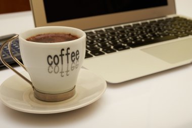 kahve ve masanın üstünde laptop