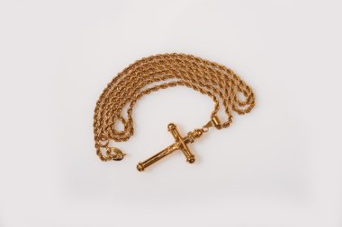Altın haç ve beyaz zemin üstüne zinciri