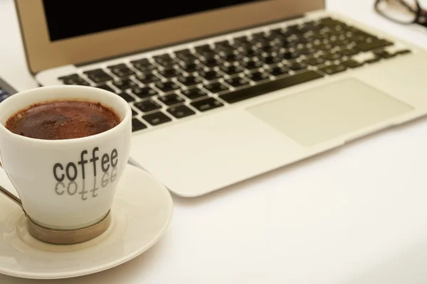 Coffee and laptop on a white table — Stock Photo, Image