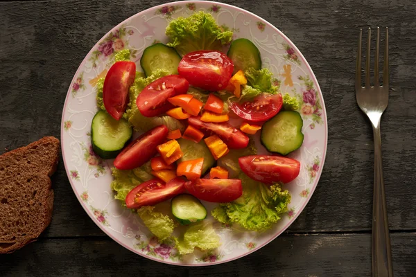 Zeleninový salát a chleba na dřevěný stůl — Stock fotografie