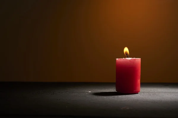 Красная свеча на красном фоне — стоковое фото