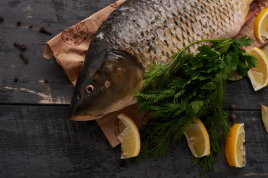 Balık sazan, Limon ve bir ahşap masa üstü üzerinde otlar