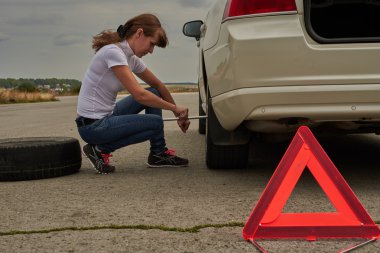 dikkat işareti için arabada yedek lastik kadın yapar