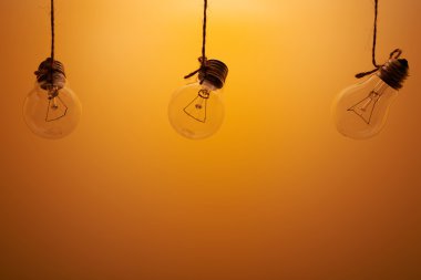 turuncu bir arka plan üzerinde üç akkor lambalar