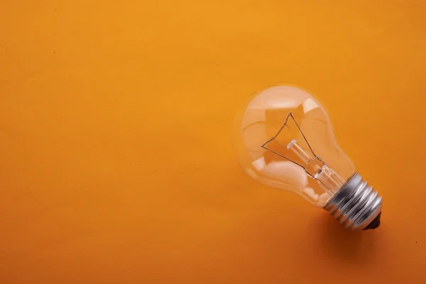 Lampadina su sfondo arancione — Foto Stock