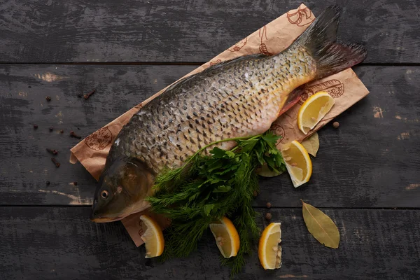 Balık sazan, Limon ve ahşap bir masa üzerinde otlar