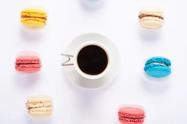 Multicolored macaroon and coffee on top of a white background — Stock Photo, Image