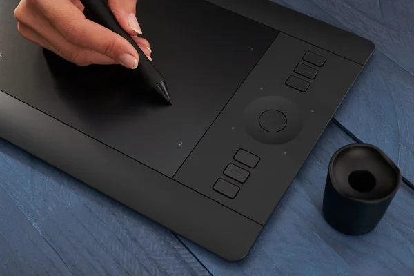 hand draws a black professional graphics tablet