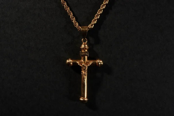 Золотой крест на цепи на черном фоне — стоковое фото