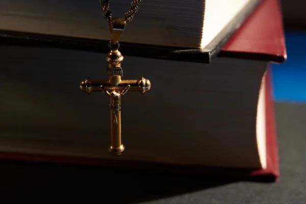 Goldkreuz hängt an Buch — Stockfoto