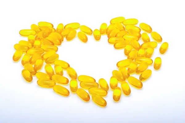 Rybí olej kapsle ve tvaru žluté srdce — Stock fotografie