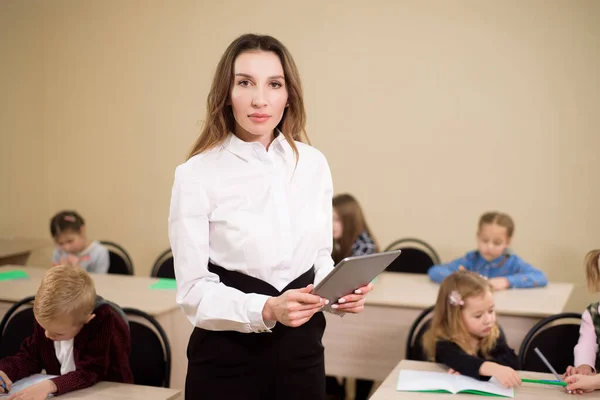 Education, elementary school, learning and people concept. Teacher and students in the background.