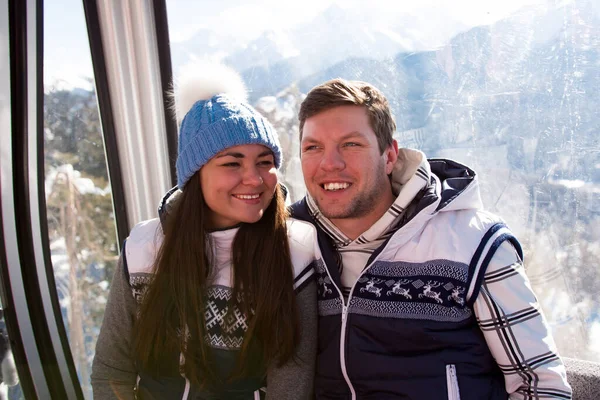 Ski lift, skiing, ski resort - happy skiers on ski lift.