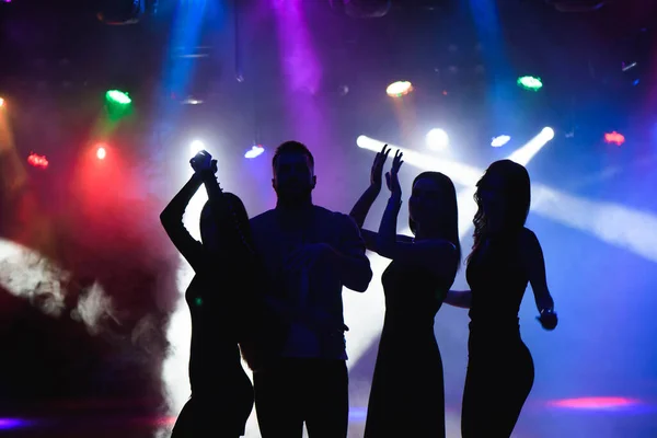 Party, holidays, celebration, nightlife and people concept - group of happy friends dancing in night club.