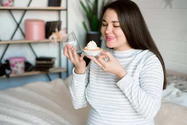 Hungry pregnant woman eating unhealthy food - cakes. Sweet cravings during pregnancy concept.