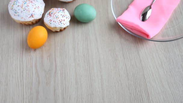 Las manos ponen sobre la mesa un plato con un pastel de Pascua con glaseado blanco . — Vídeos de Stock