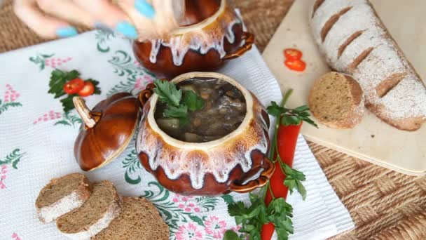 Ajouter du sel à la soupe dans une casserole sur une table de vacances russe . — Video