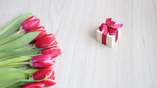 Rot-weiße Tulpen auf einem weißen Tisch bewegen sich langsam aus dem Rahmen. — Stockvideo