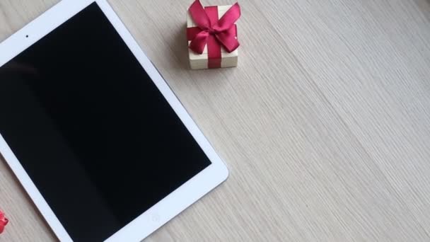 Tulipani, tablet e confezione regalo sdraiati su un tavolo bianco — Video Stock