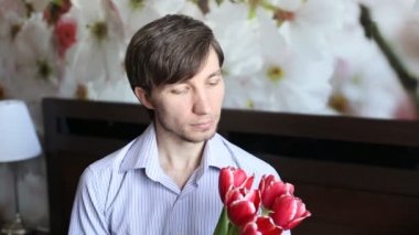 Çekici erkek çiçekler ve verir çiçek kameraya bakarak